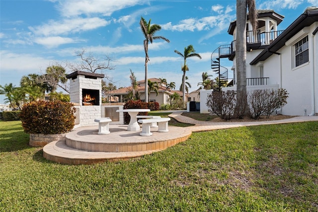 view of yard featuring an outdoor brick fireplace and stairs