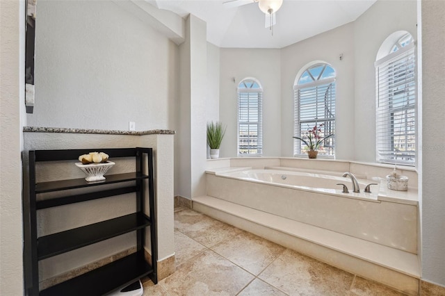 bathroom with ceiling fan, a garden tub, and tile patterned flooring