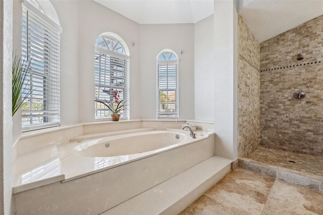 full bath with a garden tub and a tile shower