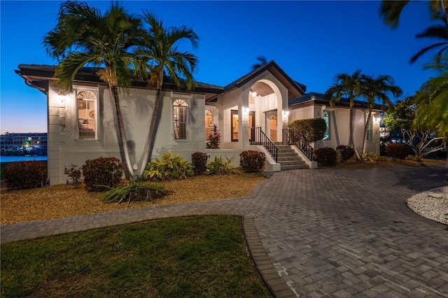 mediterranean / spanish-style home with stucco siding and decorative driveway
