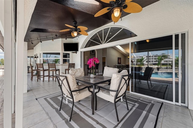view of patio / terrace with ceiling fan, an outdoor bar, and outdoor dining area