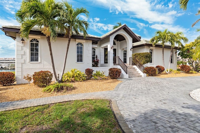 view of front facade with stucco siding and decorative driveway