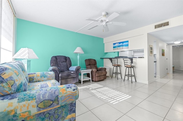 tiled living room with ceiling fan