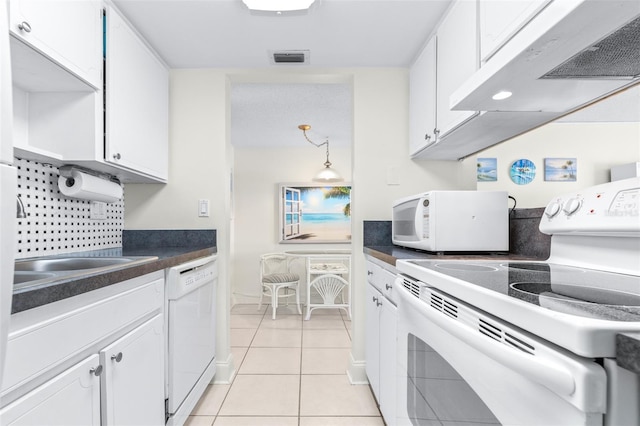 kitchen with white cabinets, light tile patterned floors, and white appliances