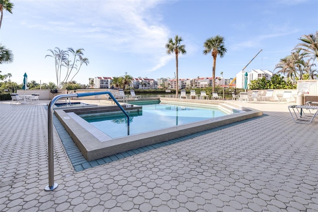 view of pool with a jacuzzi and a patio