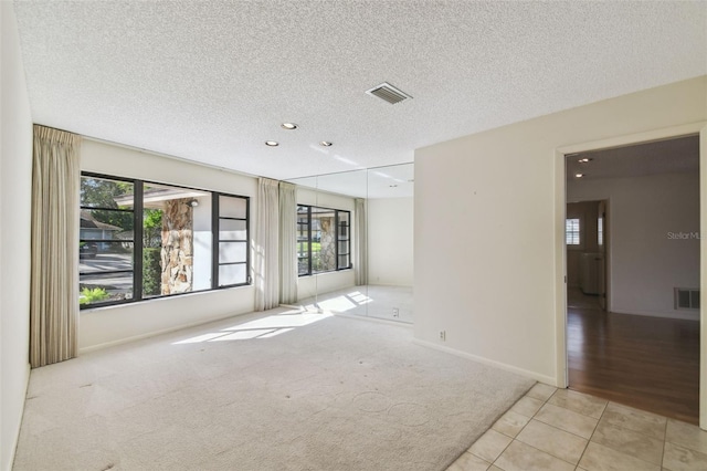 tiled spare room featuring a textured ceiling