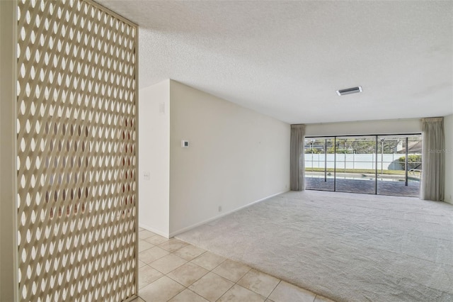 carpeted empty room featuring a water view and a textured ceiling