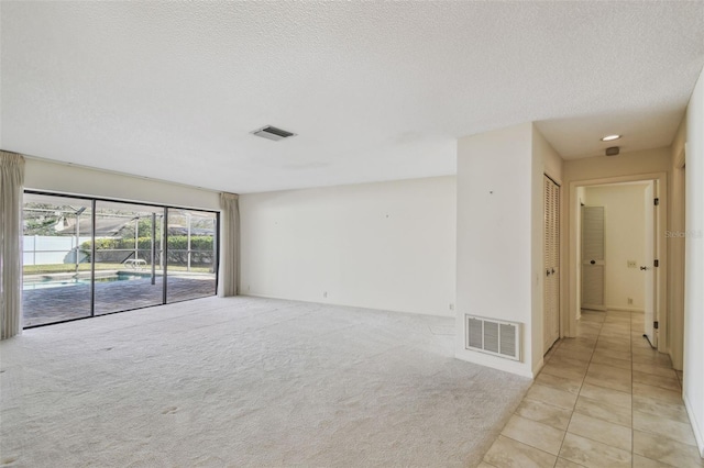 carpeted spare room featuring a textured ceiling