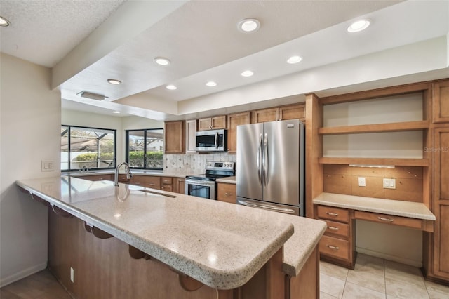 kitchen with backsplash, a kitchen breakfast bar, stainless steel appliances, and kitchen peninsula