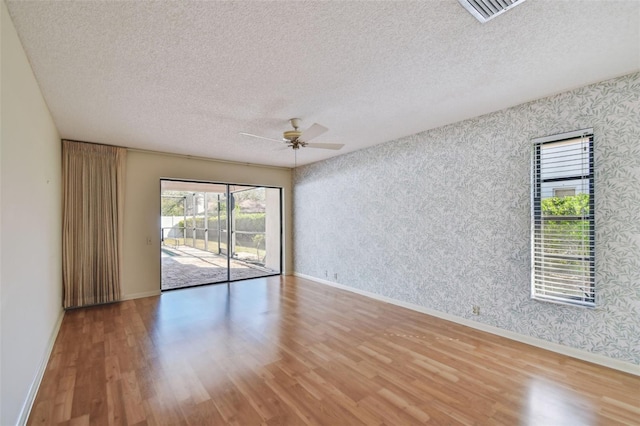 unfurnished room featuring ceiling fan, a textured ceiling, and light hardwood / wood-style flooring