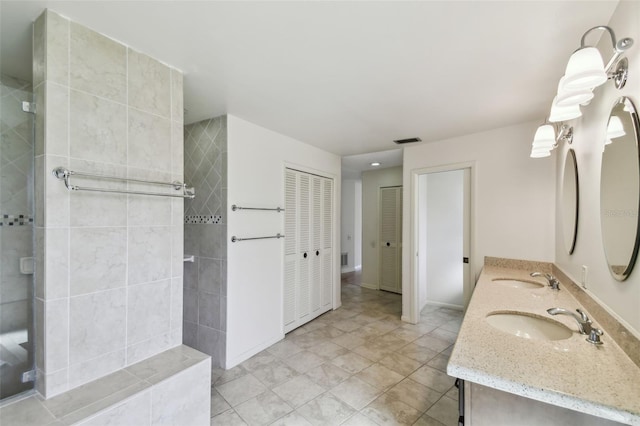 bathroom with vanity and a tile shower