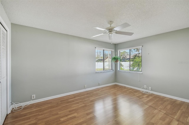 unfurnished room with hardwood / wood-style flooring, ceiling fan, and a textured ceiling