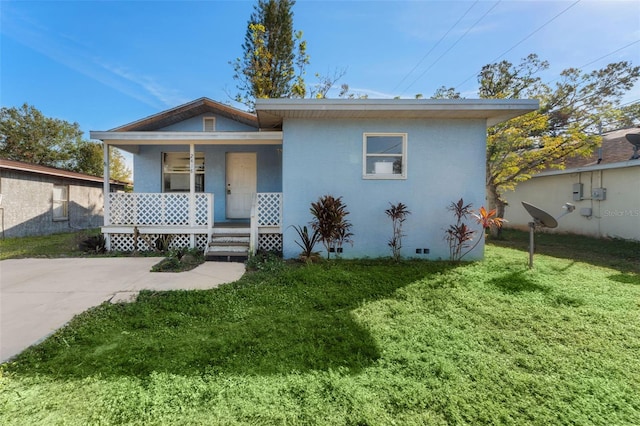 bungalow with covered porch and a front yard