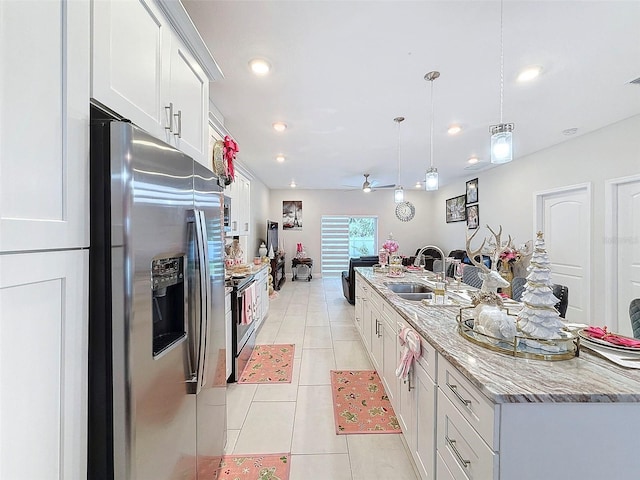 kitchen featuring a large island with sink, white cabinetry, sink, and appliances with stainless steel finishes