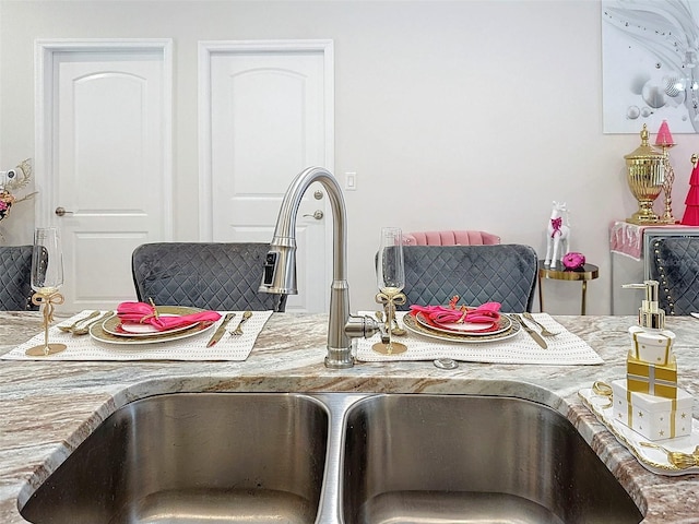 interior details featuring light stone countertops and sink