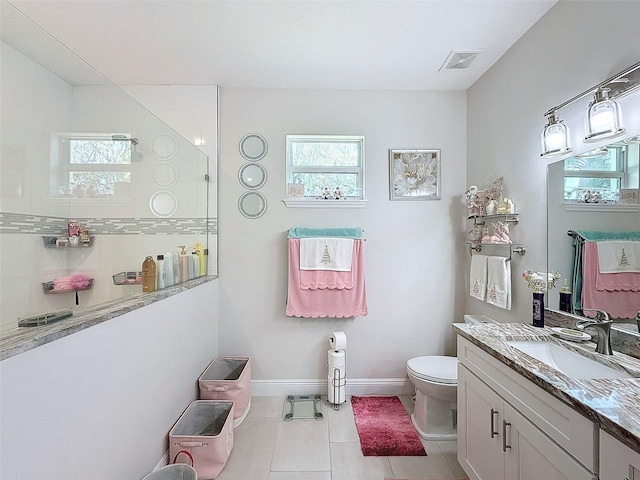 bathroom with toilet, vanity, tile patterned floors, and walk in shower