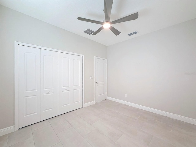 unfurnished bedroom with ceiling fan, light tile patterned floors, and a closet