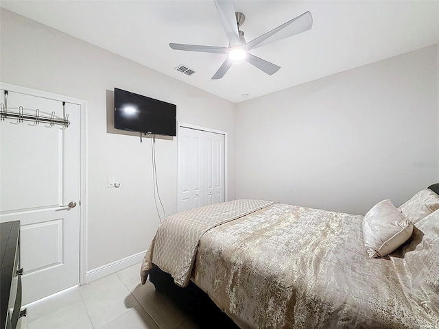 tiled bedroom with ceiling fan and a closet