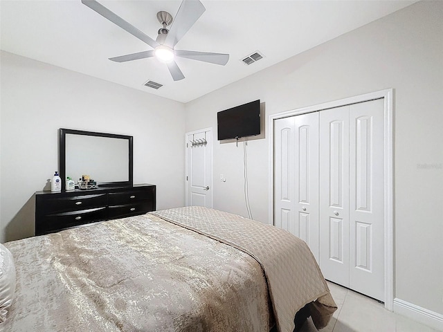 tiled bedroom with ceiling fan and a closet