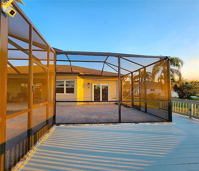 deck with glass enclosure and a patio area