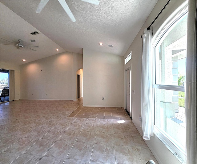 unfurnished room featuring visible vents, arched walkways, a ceiling fan, lofted ceiling, and light tile patterned flooring