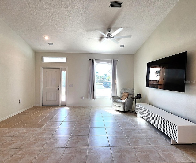 entrance foyer with light tile patterned floors, baseboards, visible vents, ceiling fan, and a textured ceiling