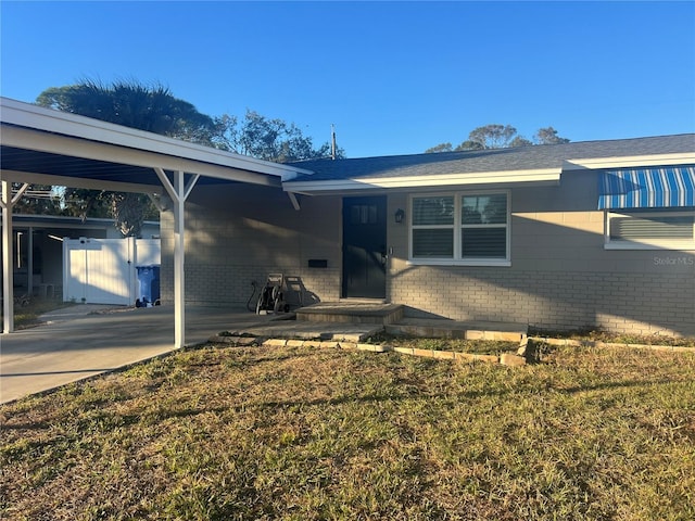 single story home with a front lawn and a carport