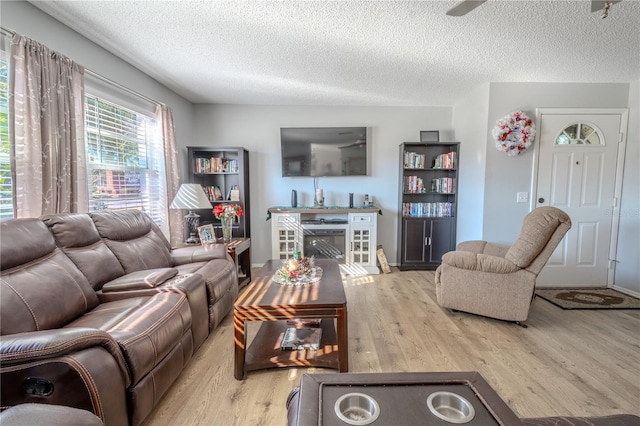 living room featuring a textured ceiling and light hardwood / wood-style floors