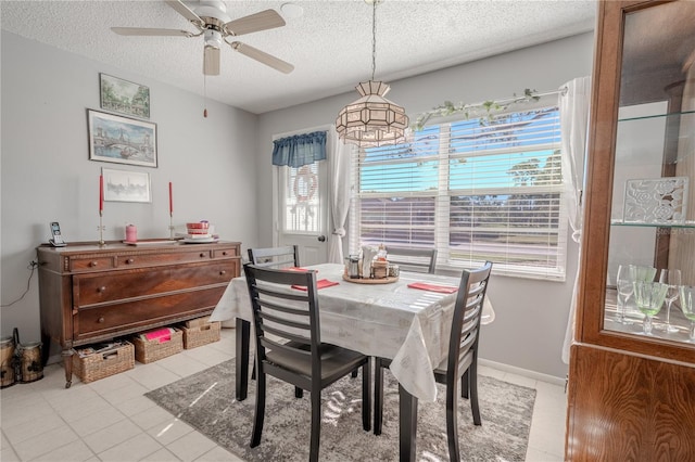 dining area with light tile patterned floors, a textured ceiling, a wealth of natural light, and ceiling fan