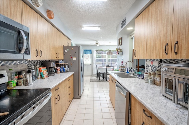 kitchen featuring sink, ceiling fan, tasteful backsplash, light tile patterned flooring, and stainless steel appliances