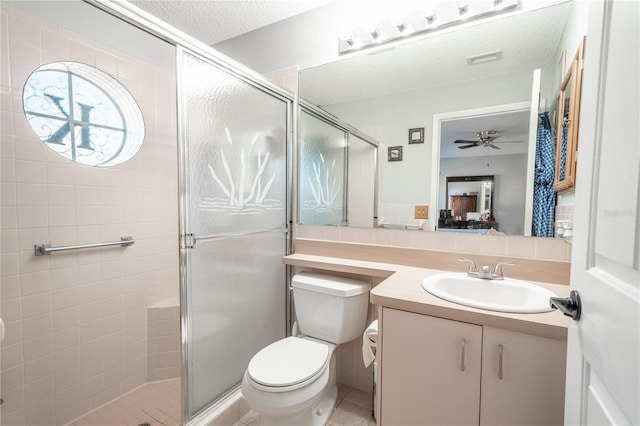 bathroom with tile patterned flooring, a textured ceiling, toilet, vanity, and a shower with shower door