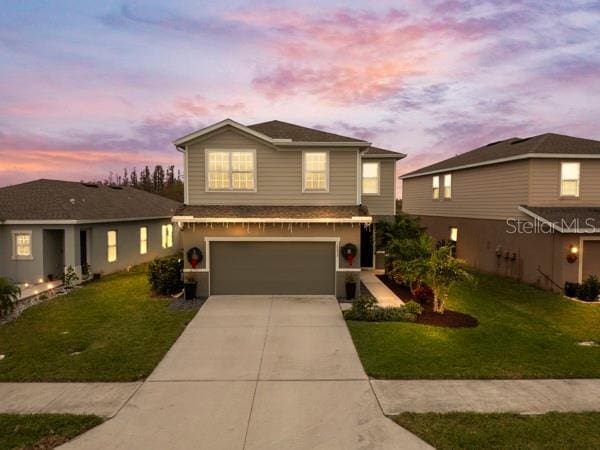 front of property featuring a lawn and a garage