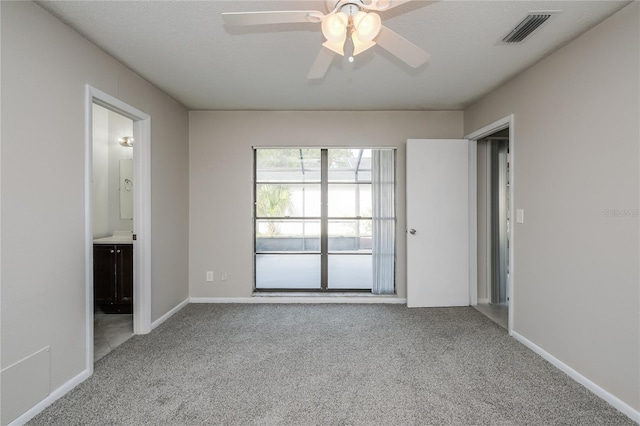 carpeted spare room featuring ceiling fan and a textured ceiling