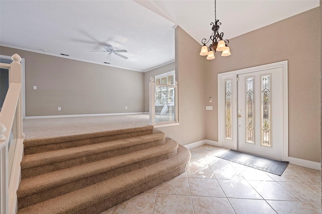 entryway featuring light tile patterned floors and ceiling fan with notable chandelier