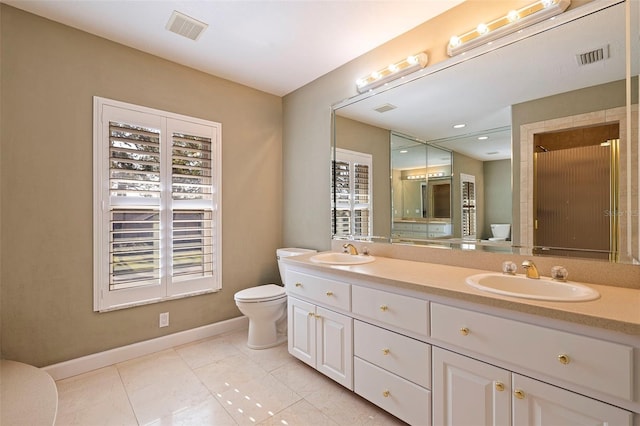 bathroom with tile patterned floors, vanity, a healthy amount of sunlight, and toilet