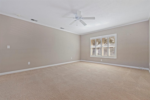 carpeted empty room featuring ceiling fan and crown molding