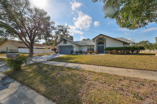 ranch-style home with a garage and a front lawn