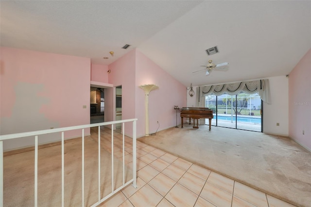 interior space featuring carpet flooring, vaulted ceiling, and ceiling fan