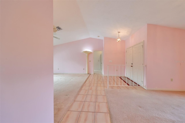 empty room featuring light colored carpet and lofted ceiling