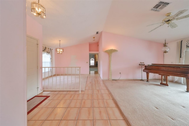 interior space with ceiling fan with notable chandelier, light colored carpet, and lofted ceiling