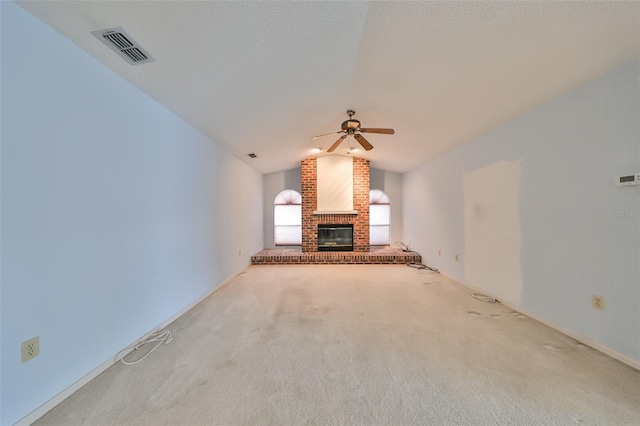 unfurnished living room featuring ceiling fan, a fireplace, light carpet, and vaulted ceiling