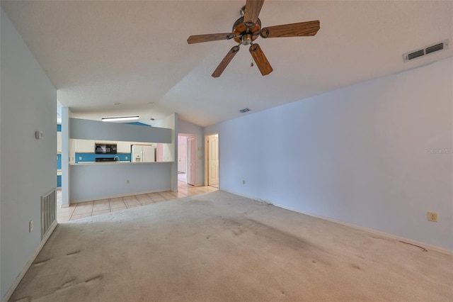 unfurnished living room with ceiling fan, lofted ceiling, and light carpet