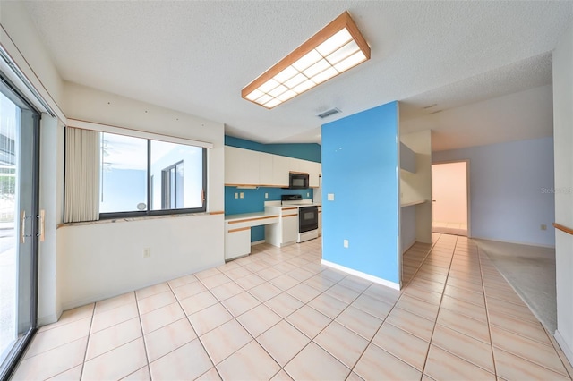 kitchen featuring white electric range oven, white cabinetry, a textured ceiling, and light tile patterned floors