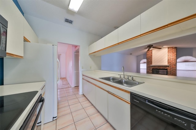 kitchen featuring dishwasher, a fireplace, white cabinetry, and sink