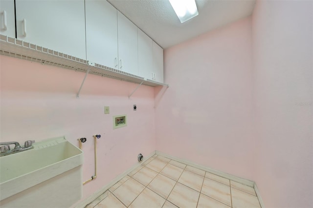 washroom with cabinets, hookup for a washing machine, hookup for an electric dryer, a textured ceiling, and sink