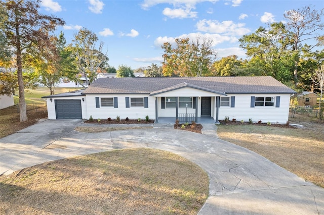 ranch-style home with covered porch, a garage, and a front lawn