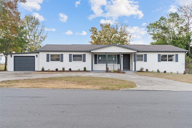 ranch-style home with covered porch, a garage, and a front yard