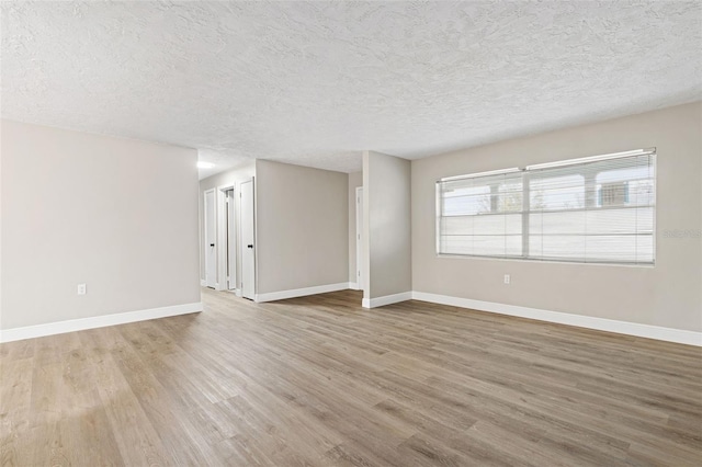 unfurnished room featuring hardwood / wood-style floors and a textured ceiling