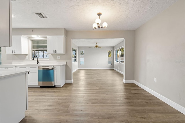 kitchen featuring dishwasher, ceiling fan with notable chandelier, decorative light fixtures, light hardwood / wood-style floors, and white cabinetry