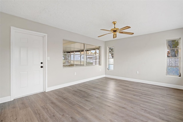 spare room featuring hardwood / wood-style flooring, a textured ceiling, and a wealth of natural light